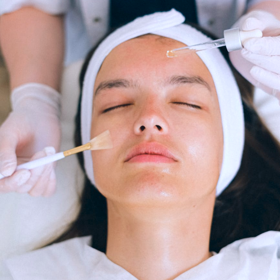 A female client closes her eyes and relaxes while receiving a facial
