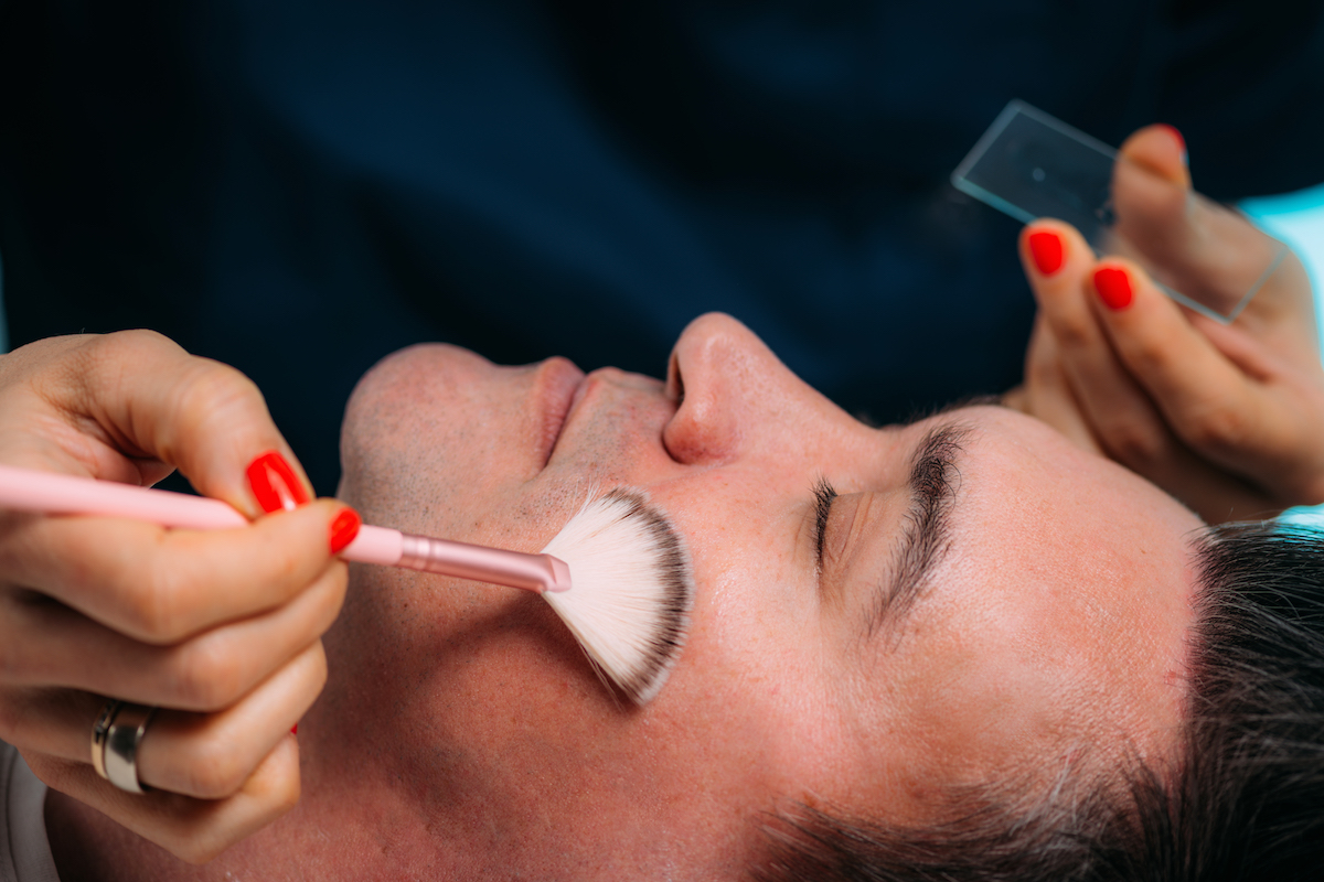 A female client closes her eyes and relaxes while receiving a facial