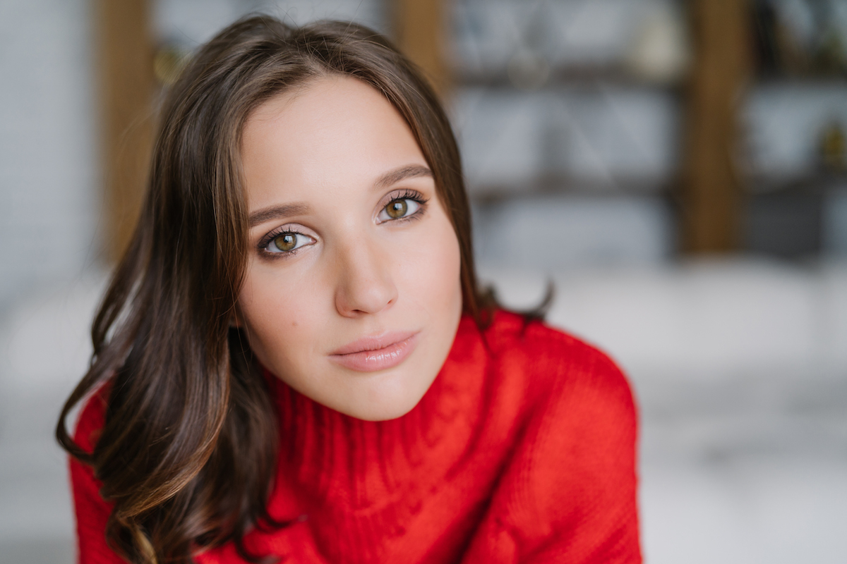 Close up of woman wearing a red sweater and staring into the camera
