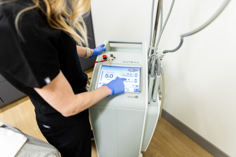 A Kansas City Skin and Cancer provider changes one of the settings on a Cutera machine.