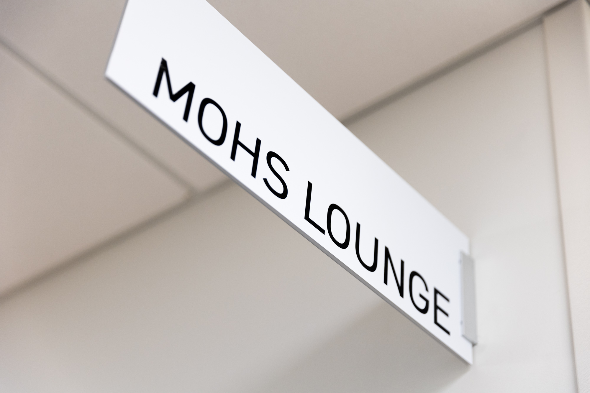 A sign attached to the top of a wall reads "Mohs Lounge."